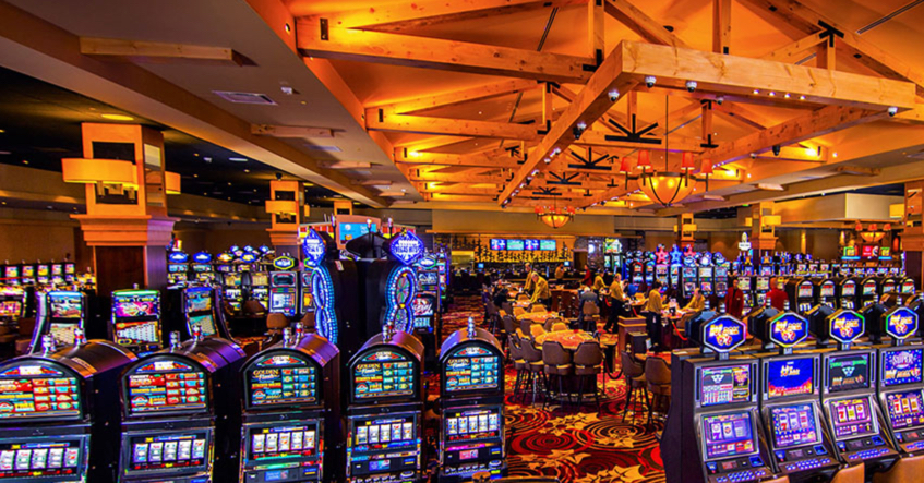 Oxford Casino floor in Maine with rows of slot machines, table games, and players enjoying the lively gaming atmosphere
